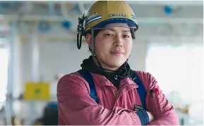腕を組む作業服を着た男性