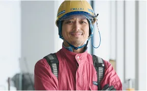 腕を組む作業服を着た男性