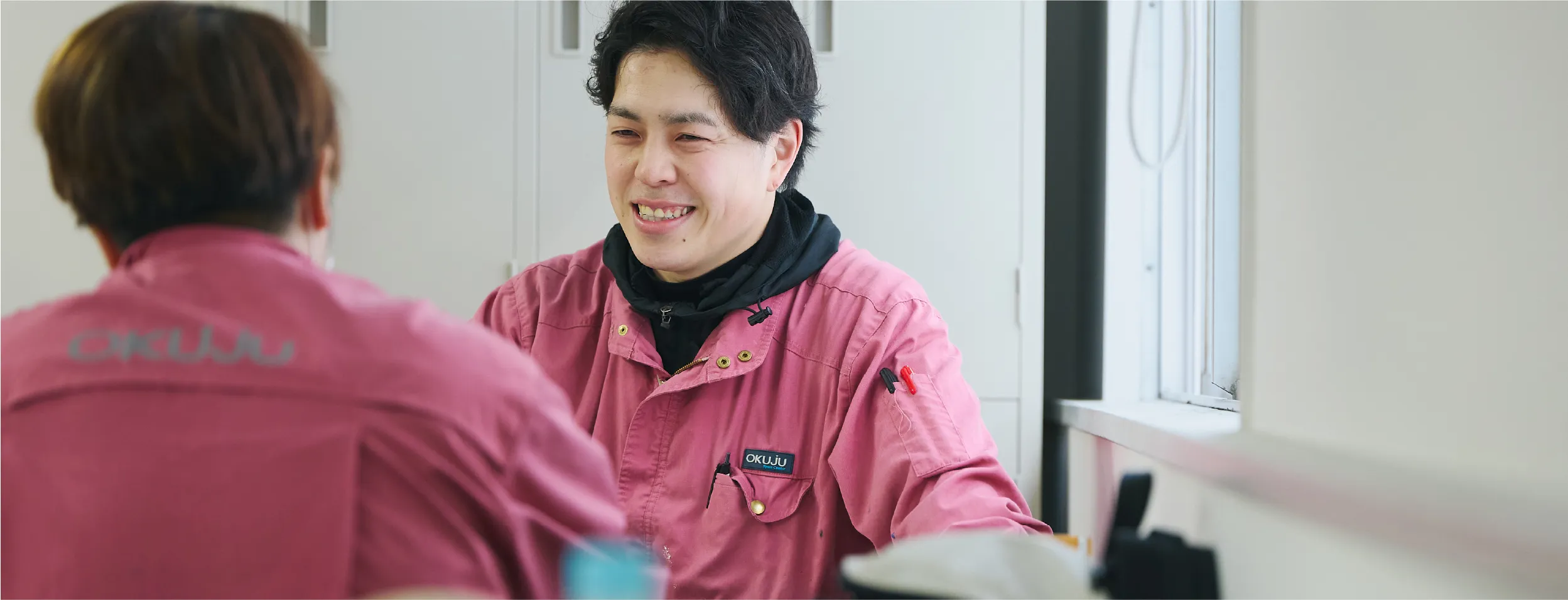 談笑する作業着を着た男性
