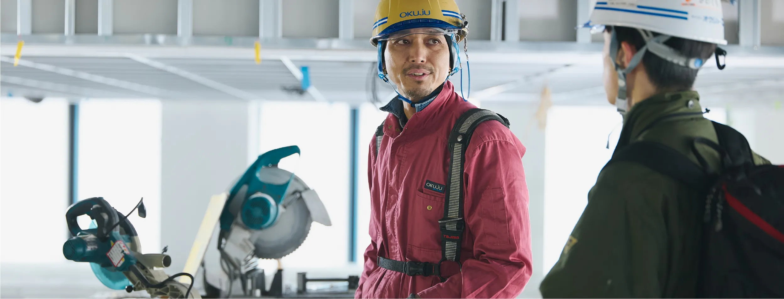 談笑する作業着を着た男性