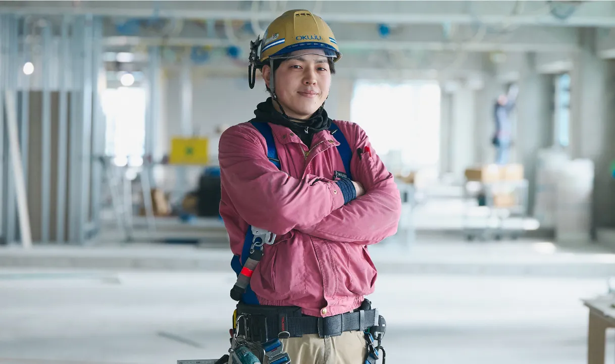 腕を組む作業服を着た男性