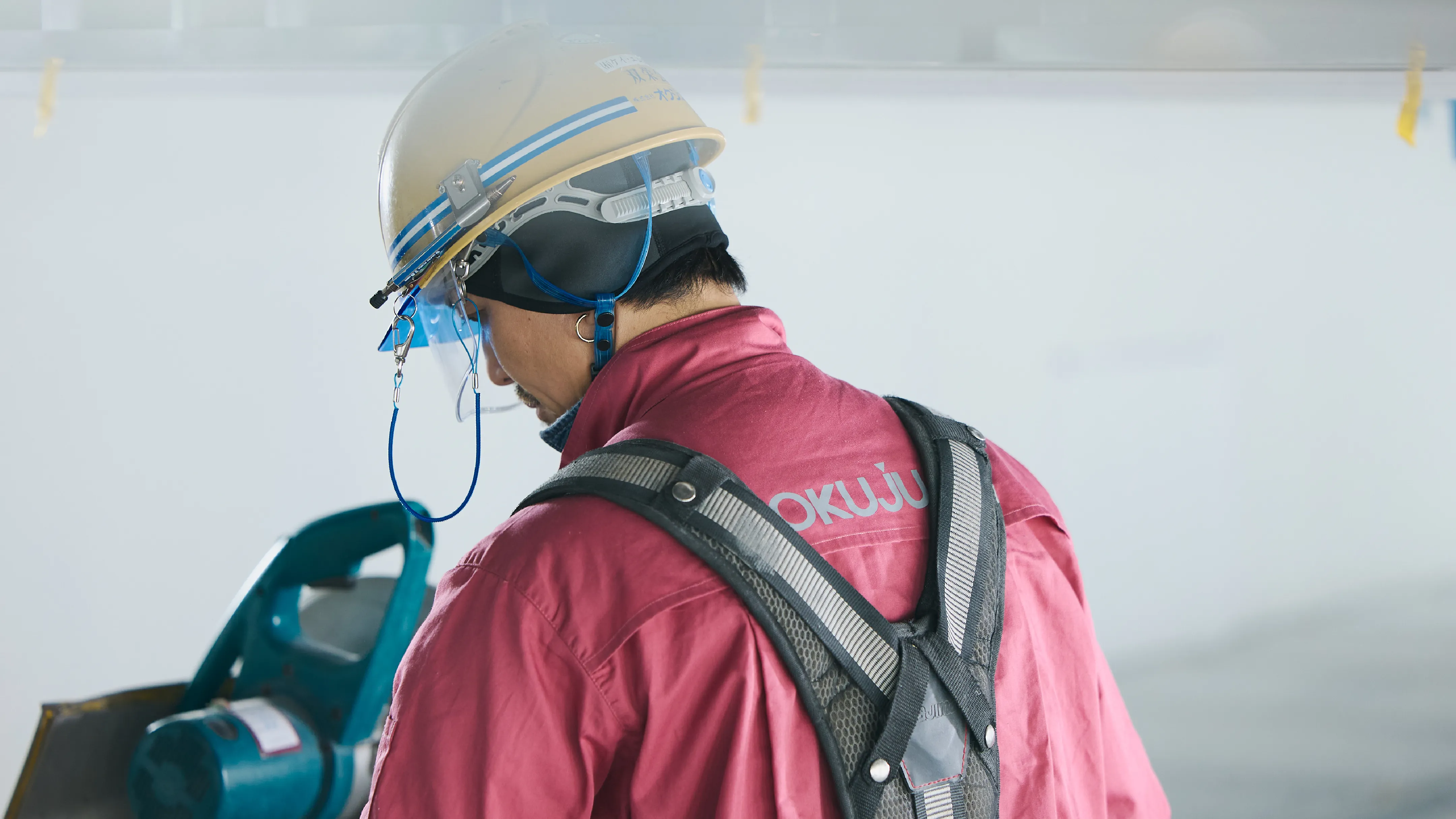 機械を操縦する作業服を着た男性